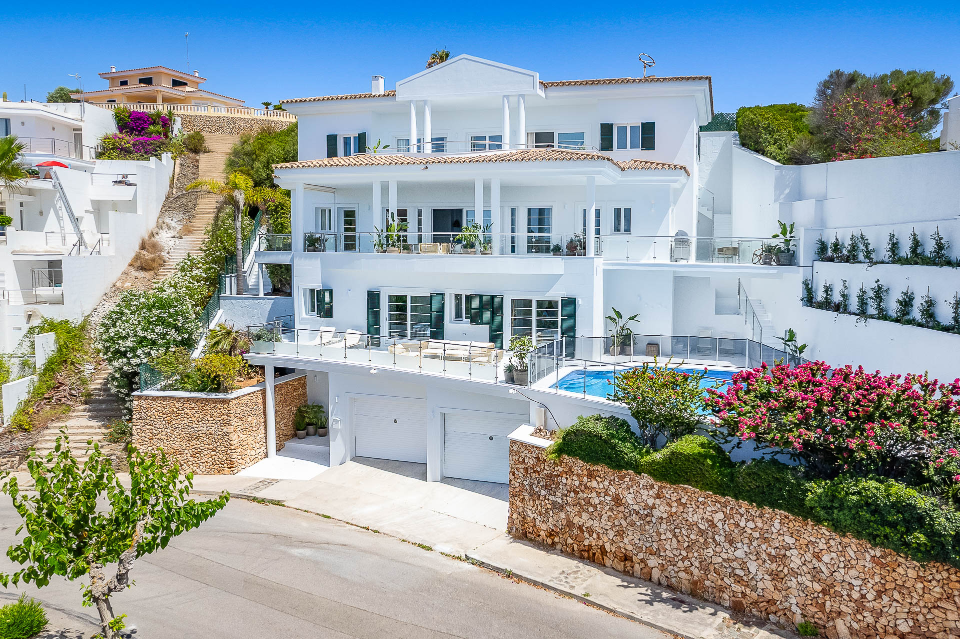 Admirez la vue sur la mer depuis votre piscine privée dans cette magnifique villa en bord de port, située dans le quartier résidentiel prisé de Cala Llonga, près de Mahón.